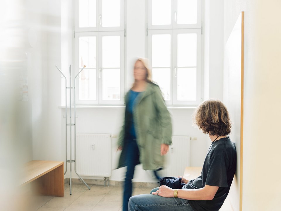Zwei Personen im hellen Wartezimmer der Hausarztpraxis Dr. Seiler und Wiesinger.